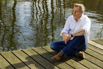 Mann sitzt entspannt in der Sonne