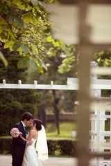 Bride and groom kissing in the park