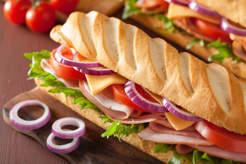 long baguette sandwich with ham cheese tomato lettuce - obrazy, fototapety, plakaty