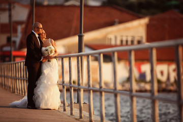 Bride and groom on a bridge near river