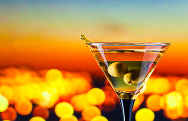 glass with martini and green olives
