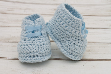 Pale Blue Baby Booties on wood background
