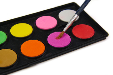 Watercolor paint and brush in black box on a white background