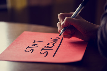 Handwritten Stay Strong Phrase on red Sticky Note