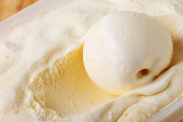 creamy vanilla ice cream scoop in a white cup