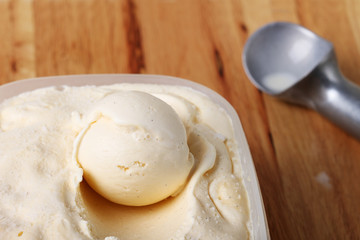 creamy vanilla ice cream in a white cup with a special spoon