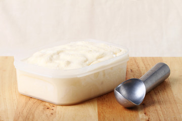 creamy vanilla ice cream in a white cup with a special spoon