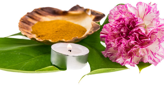 Spa set concept with turmeric powder decorated with pink carnati