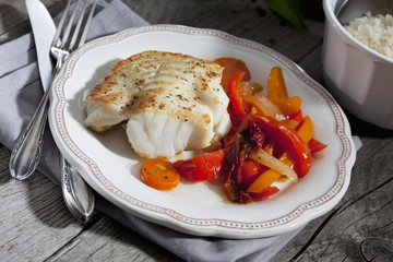 Fischgericht, gebratenes Kabeljau mit Gemüse auf Teller