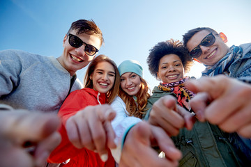 Obraz premium happy teenage friends pointing fingers on street