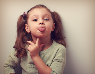 Thinking grimacing girl showing tongue with finger. Vintage clos