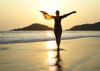 Young woman meditating on Palolem beach. South Goa, India - obrazy, fototapety, plakaty