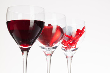 Wine glasses with red wine, heart and golf ball