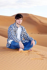 Fototapeta na wymiar Man alone in the desert on the sand dune