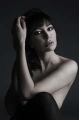 Beautiful naked woman sitting in a studio