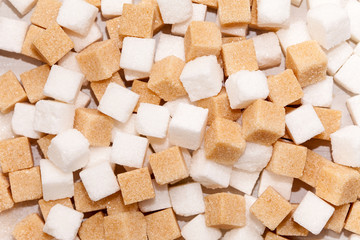 Cubes of sugar cane brown and white refined background