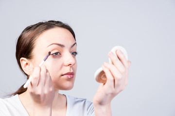 Young woman applying eye makeup © kolotype