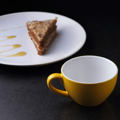 Cake on round white plate and yellow cup