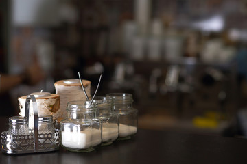 Sugar bowls on the black tabke in a bar