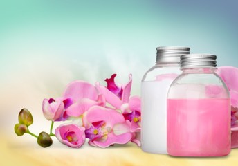 Cosmetics. Pink soap bottles and flowers