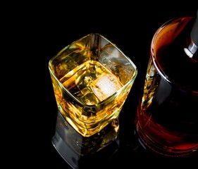 top of view of whiskey with ice in glass on black background