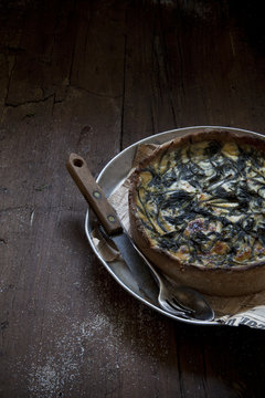 baked green wild asparagus quiche on wooden table
