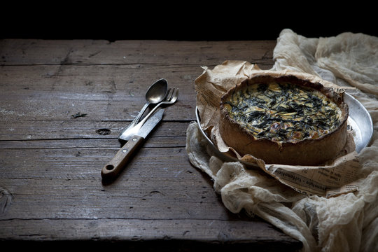 baked green wild asparagus quiche on wooden table