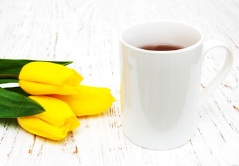 Cup of tea and yellow tulips