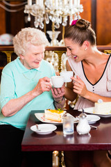 Senior woman and granddaughter at coffee in cafe