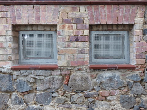 Kellerfenster im por&ouml;sen Mauerwerk eines Altbau aus Bruchstein und Naturstein in Naturfarben in Wettenberg Krofdorf-Gleiberg bei Gie&szlig;en in Hessen
