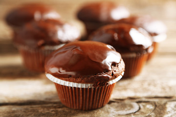 Tasty homemade chocolate muffins on wooden table