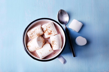 Mug of cocoa with marshmallows on wooden table background