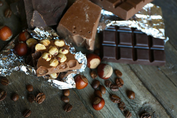 Set of chocolate with nuts on wooden table, closeup