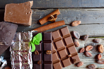 Delicious chocolate with spices on wooden table, closeup
