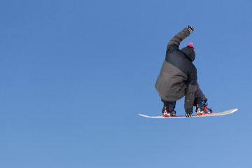 Snowboarder jumps in Snow Park