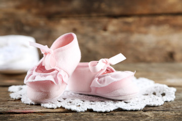 Fototapeta na wymiar Pink toddler shoes on wooden background