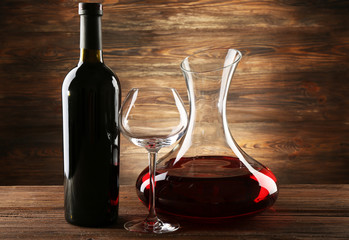 Glass carafe of wine on wooden background