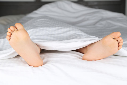 kids feet under a white blanket