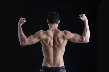 Fototapeta na wymiar Back of shirtless muscular young man doing double biceps pose
