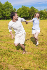 Handsome Caucasian Man Pulling Her Smiling Lady by Hand. Couple