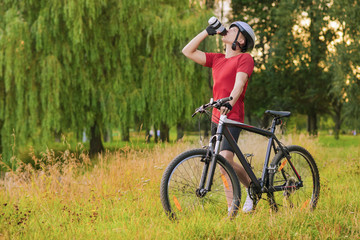 Cycling Concept: Young Caucasian Male Cyclist Having water Break