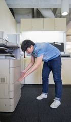 woman inserting paper in laser printer cartridge in office