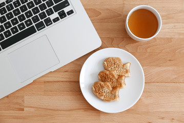 Fish shapes waffle with tea and laptop