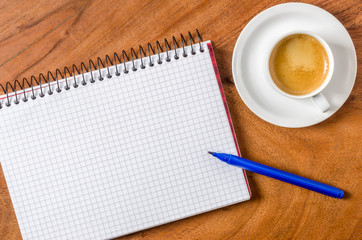 Unbeschrifteter Notizblock mit Stift und Espresso