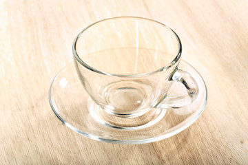 transparent glass cup and saucer close-up on wooden table