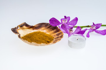 turmeric powder in seashell with Pink mokara orchids and tea lig