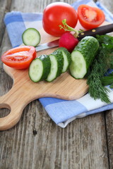 Cucumbers and tomatoes on a cutting board