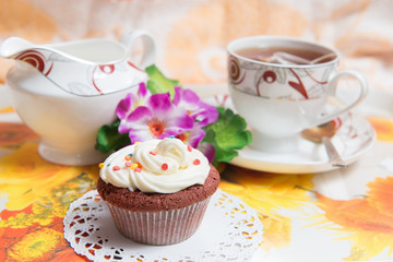 Sweet cake with cup of tea and flowers