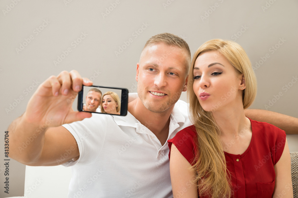 Wall mural young couple taking a selfie