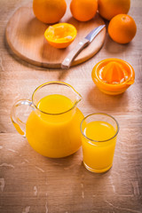 juice in glass pitcher knife fruits squeezer on wooden table